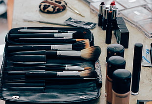 black handled makeup brush set on black leather organizer