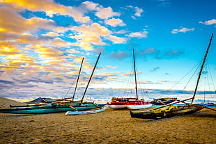 sailboats on shore at sunset
