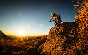 man riding on mountain bike under The sun set HD wallpaper