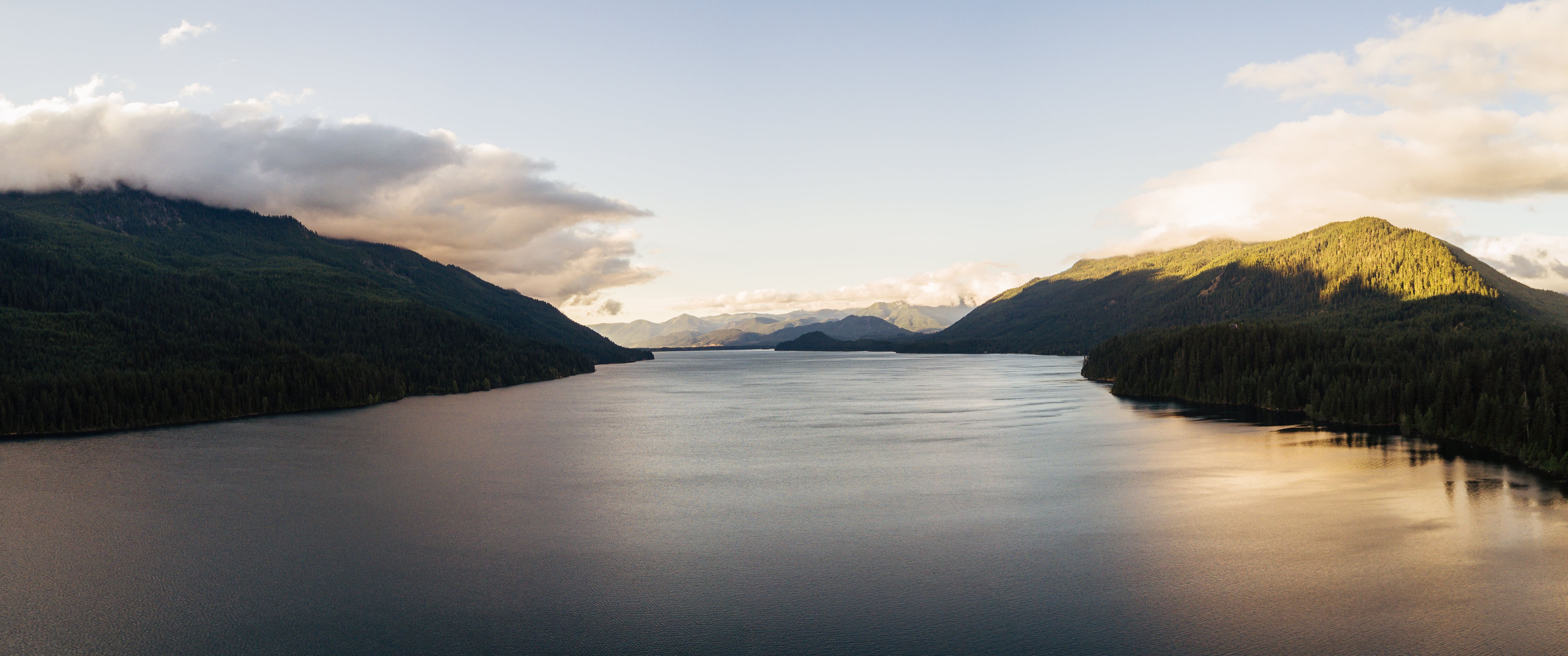 body of water near mountains at daytime