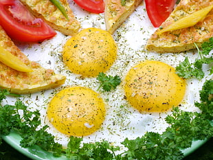 sunnyside up with green vegetable leaf and sliced tomato