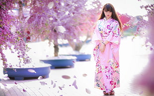 woman wearing floral kimono under cherry blossom