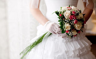 woman in wedding dress holding flower bouquet