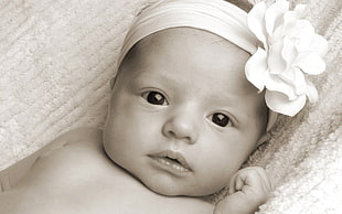 grayscale photo of baby's white headband with flower accent