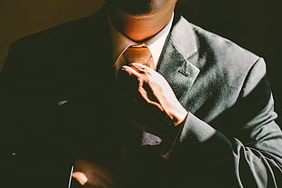 man holding brown necktie HD wallpaper