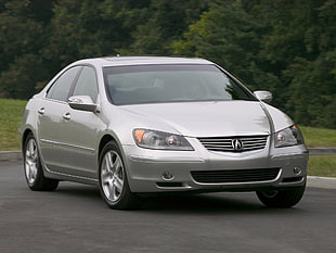 silver Acura sedan on the gray pave road in daytime