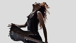 woman in black sleeveless top playing guitar