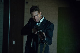 man wearing black suit holding rifle
