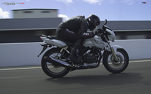 man in black suit riding motorcycle