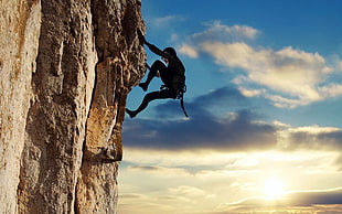 person climbing on cliff digital wallpaper