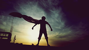 silhouette photo of boy with cape