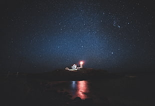 photography of lighthouse on island during nighttime