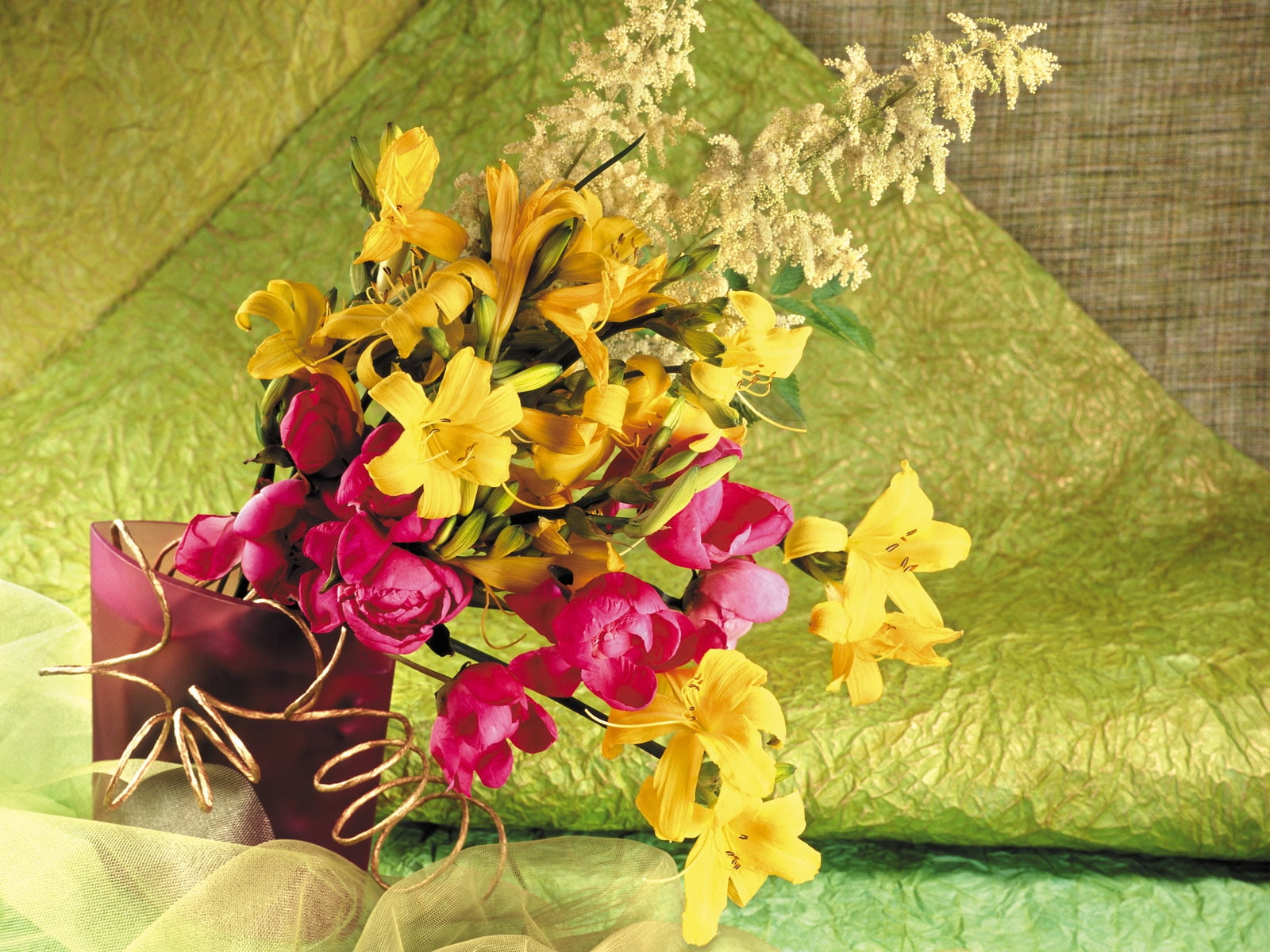 yellow and pink petaled flowers in red translucent vase