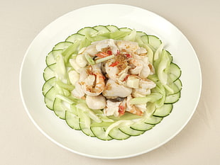 round white ceramic plate with sliced cucumber and shrimp