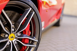 gray Ferrari 5-spoke car wheel with black tire in focus photography