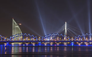 lighted bridge near city at nighttime