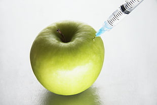 green apple fruit with syringe