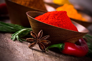 red chili powder in brown bowl in closeup photo