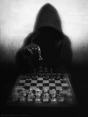 man wearing hoodie playing chess