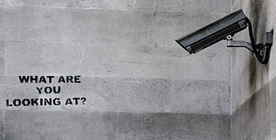 black surveillance camera with text overlay, security, wall, graffiti