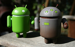 two gray and green Android figurines