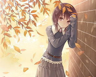girl in gray long-sleeved shirt standing beside gray brick wall