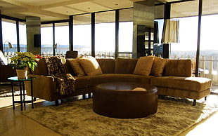 sued brown sectional sofa with round ottoman HD wallpaper