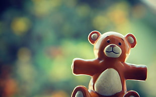 field of depth photography of brown and white bear figurine during day time