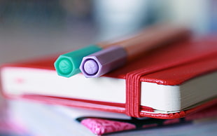 selective focus photography of purple and green pens
