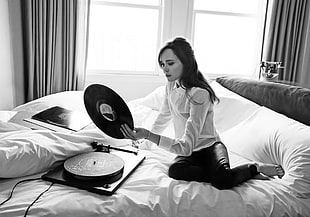 woman wearing white dress shirt holding Vinyl Disc