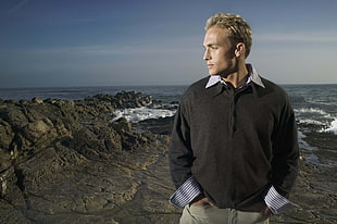 man in black collared long-sleeved shirt on seashore