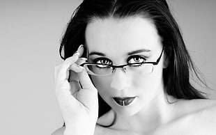 grayscale of woman holding her-half frame eyeglasses photo