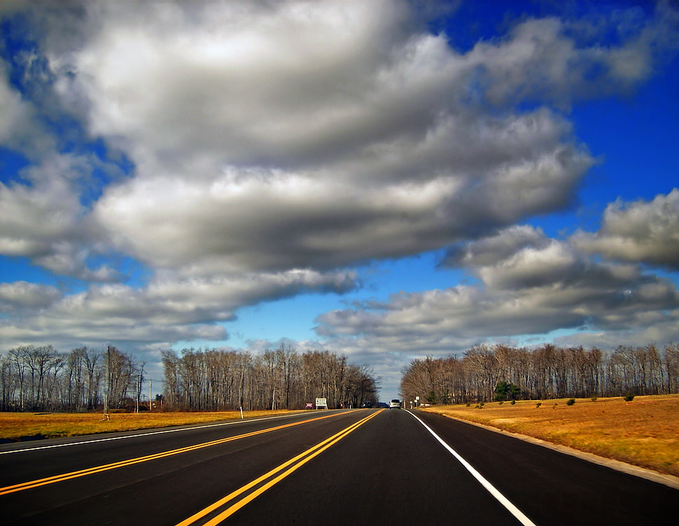 empty concrete road under white clouds HD wallpaper