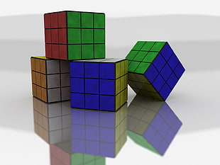 closeup photography of four 3 by 3 Rubik's cubes