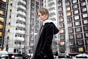 woman wearing black coat standing near buildings HD wallpaper