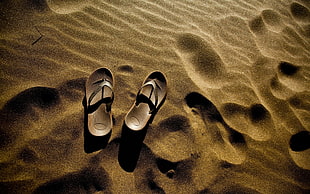 pair of flip flops on sand