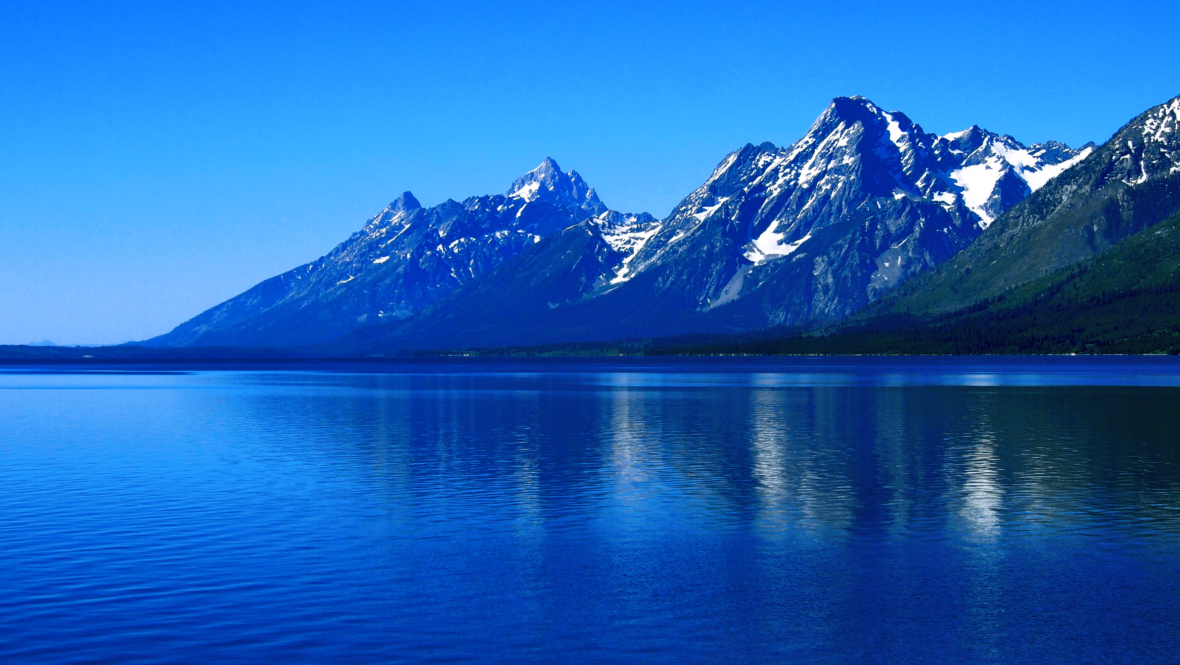 body of water near snowy mountain