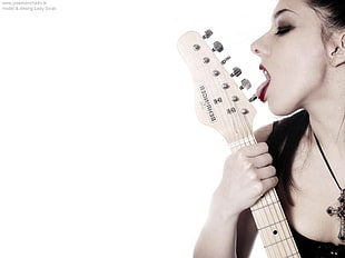 black haired woman licking gray guitar