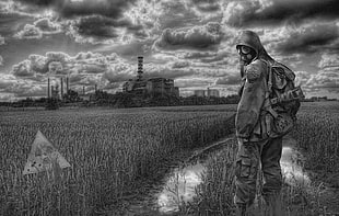 grayscale photo of person wearing gas mask in the middle of an open field