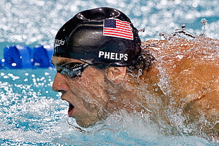 man in USA printed swimming cap and goggles in pool closeup photo
