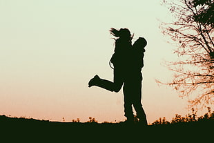 silhouette of man carrying woman