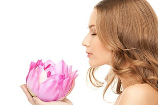 brown haired female smelling purple flower