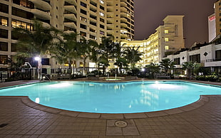 panoramic photo of pool surrounded with concrete buildings