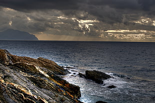 rocks near water under dark sky, genova