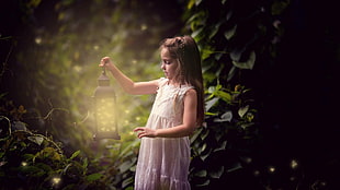 girl wearing white sleeveless dress holding lantern photography