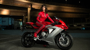 woman riding red and silver sports bike