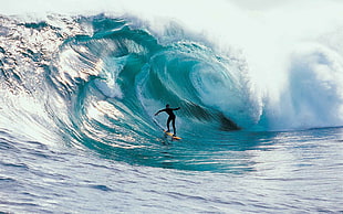 photography of person surfboarding on sea wave
