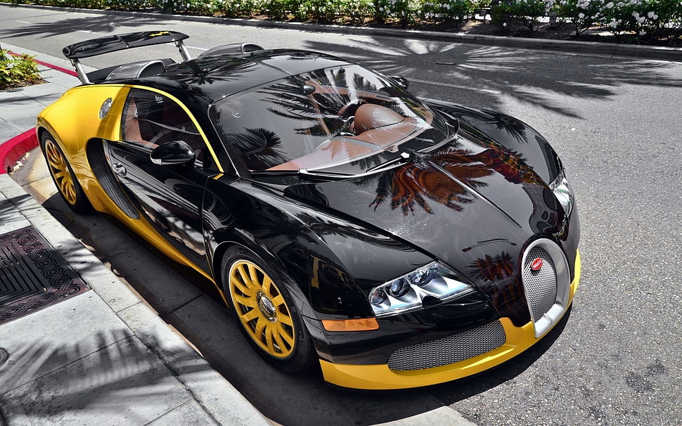 black and yellow Bugatti Veyron parked on the side of the road during daytime HD wallpaper