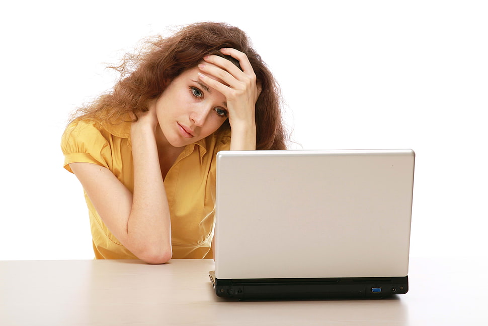 woman wearing yellow button-up shirt looking into gray laptop HD wallpaper