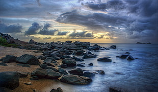 photography of rocks near sea under sky HD wallpaper